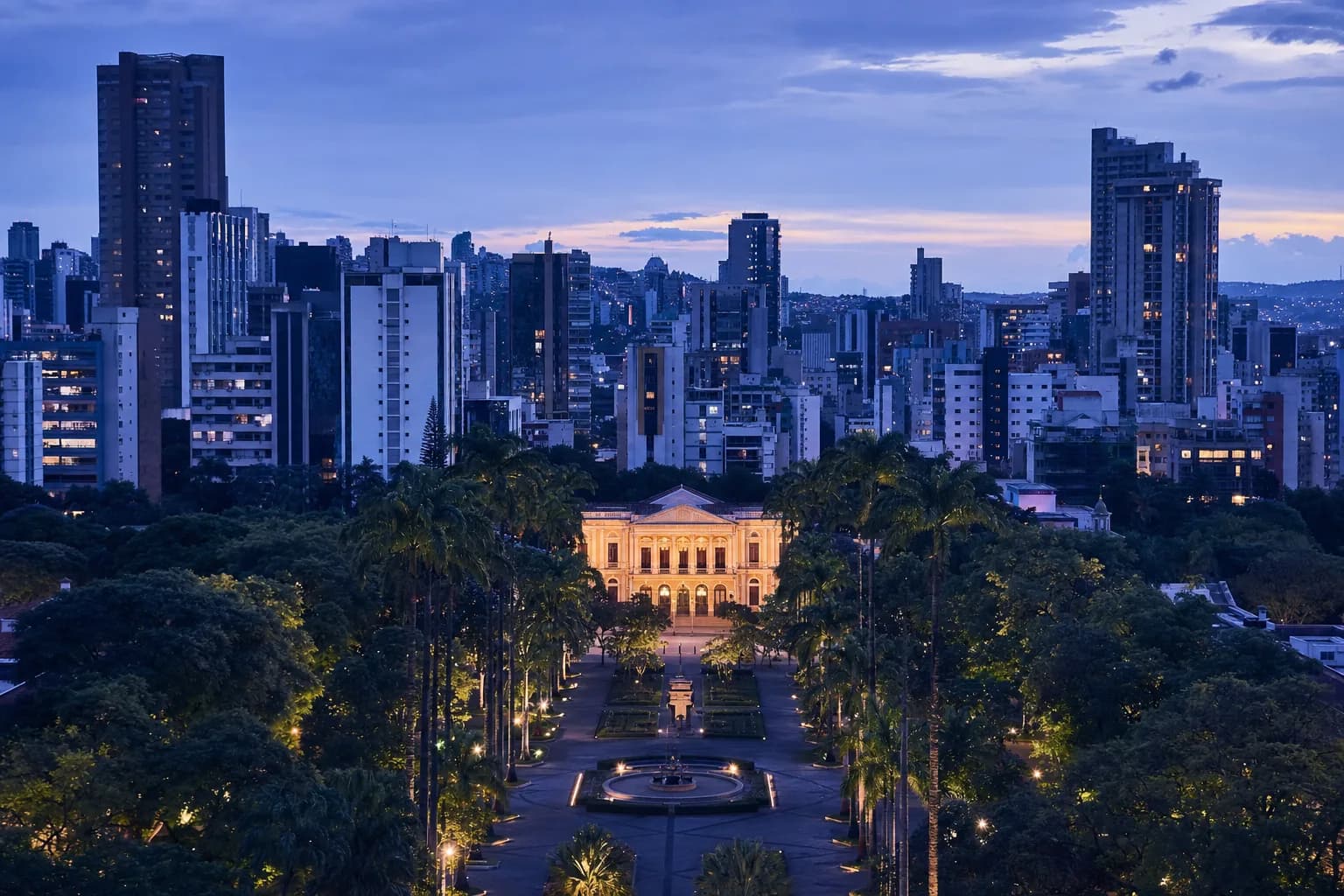Belo Horizonte at dusk, with Praça da Liberdade in the foreground and the Savassi skyline behind it